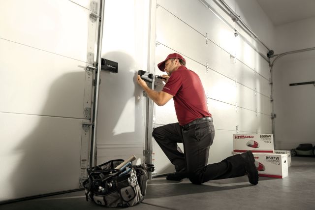 Technician doing garage door maintenance