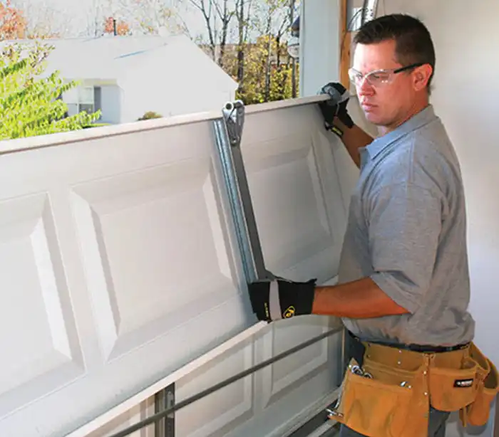 Technician replacing garage door panel
